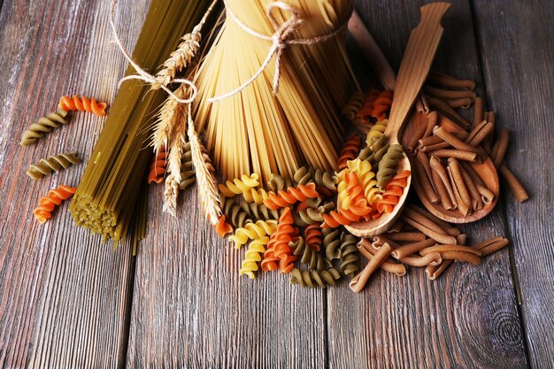 Different types of pasta on wooden