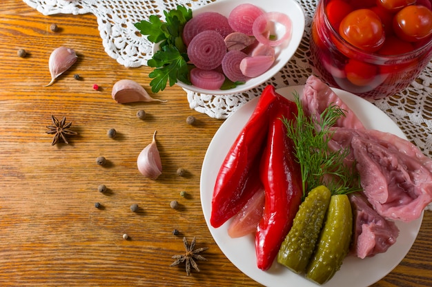 Foto diversi tipi di verdure in salamoia. cetrioli sottaceto, pomodoro, cavolo, pepe, verdure, cipolla e aglio servito sul tavolo in stile antico con tovaglia fatta a mano. verdure fermentate fatte in casa