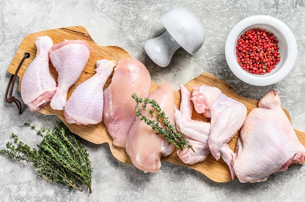 Different types of raw chicken meat, poultry. Gray background. Top view.