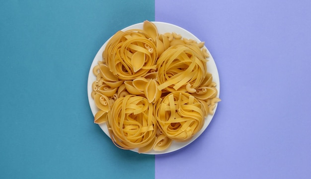 Different types of raw italian pasta in plate