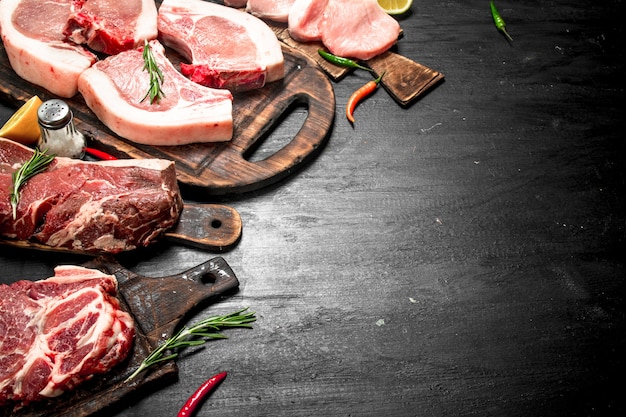 Different types of raw pork meat and beef with herb and spices.