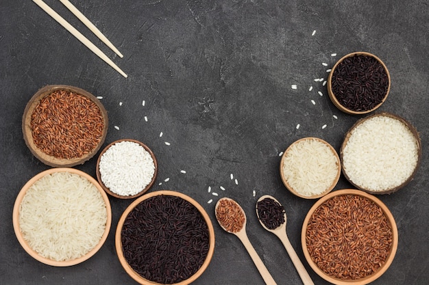 Different types of rice in ceramic bowl. Flat lay
