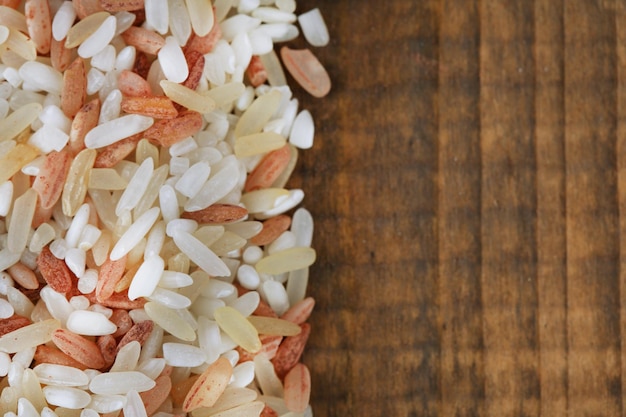 Different types of rice on wooden background