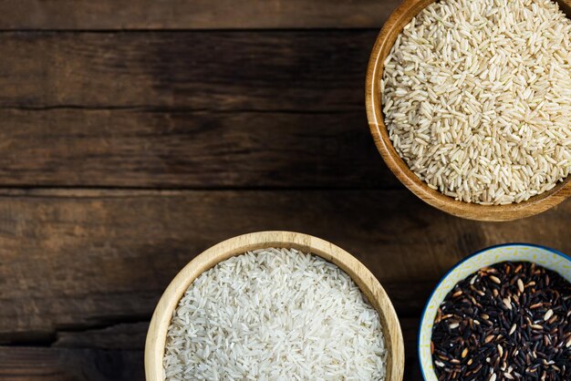 Different types of rice in wooden bowls such as basmati brown a