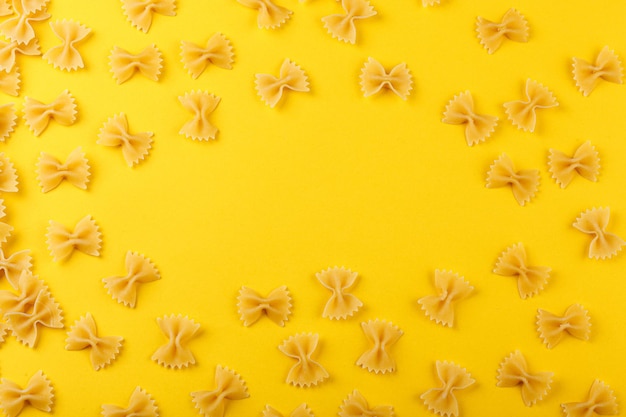 Foto diversi tipi e forme di pasta secca italiana su sfondo giallo