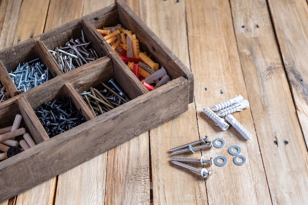 Different types and sizes of screws in wooden organizer box