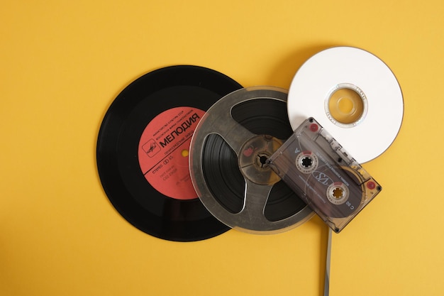 Different types of storage media from the last century against a yellow background retro storage media