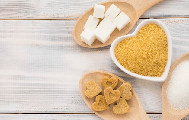 Different types of sugar on a wooden surface