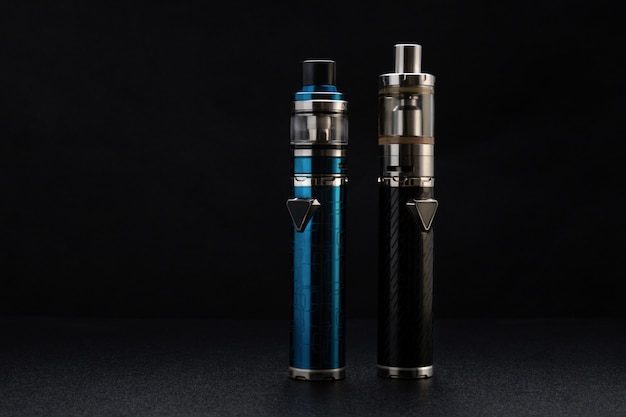 Different types of vaping devices on black background