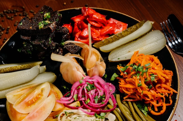 Different types of vegetables on black plate.