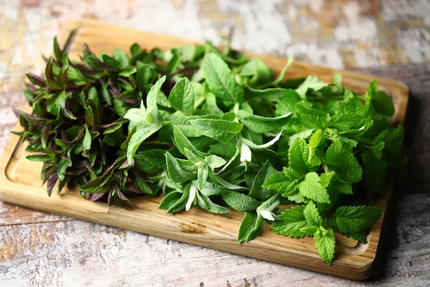 Different varieties of mint on a wooden board