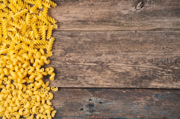 Different varieties of pasta on a wooden background