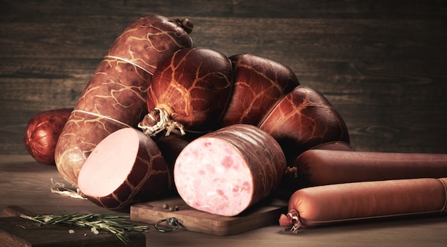 Different varieties of smoked sausages on a wooden board.\
servilat, salami. delicious sausage for any table. delicious\
food.