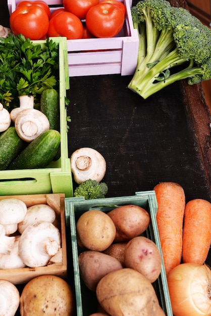 Different vegetables in boxes on wooden background top view