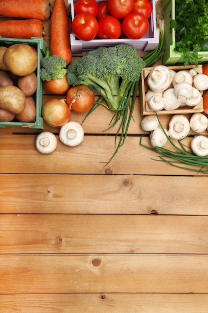 Different vegetables in boxes on wooden table top view