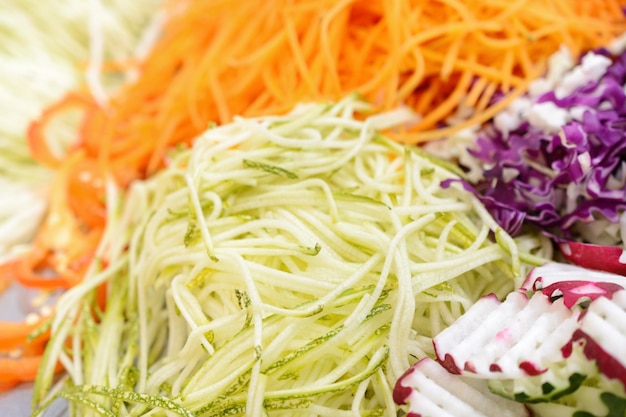 Different vegetables grated on a grater shaped