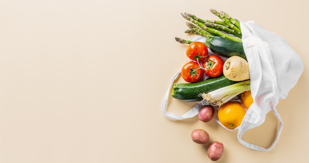 Different vegetables in textile bag on beige