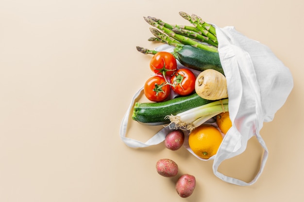 Photo different vegetables in textile bag on beige