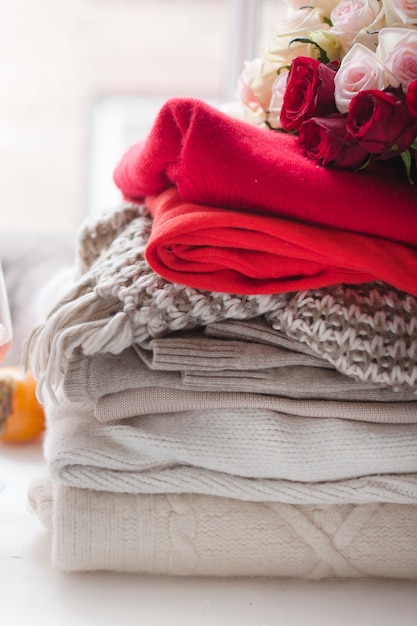 Different warm winter clothes at home near the window. Cozy photo.