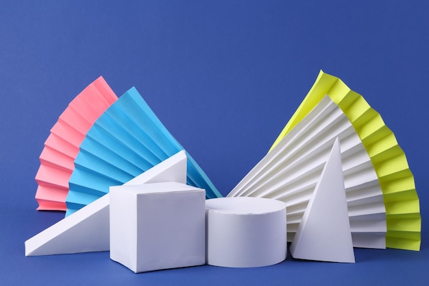 Фото Различные белые геометрические фигуры на синем фоне концепт-арт абстрактный фон витрина косметических товаров