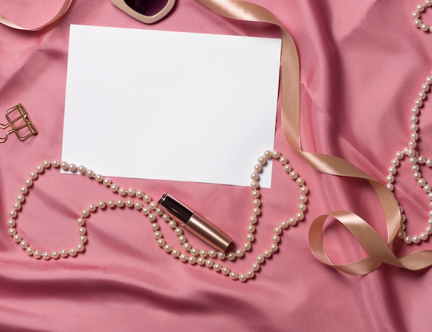 Different women accessories on pink fabric. Mock up for artwork .View from above.