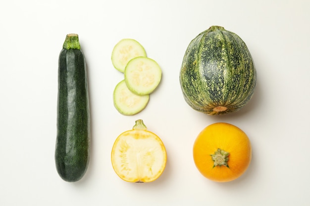 Different zucchini on white, top view