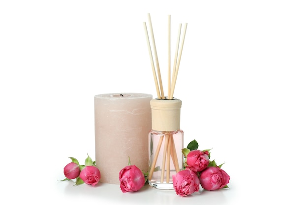 Diffuser bottle, roses and candle isolated on white background