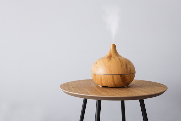 Diffuser van aromatische olie op een houten tafel op een witte achtergrond.