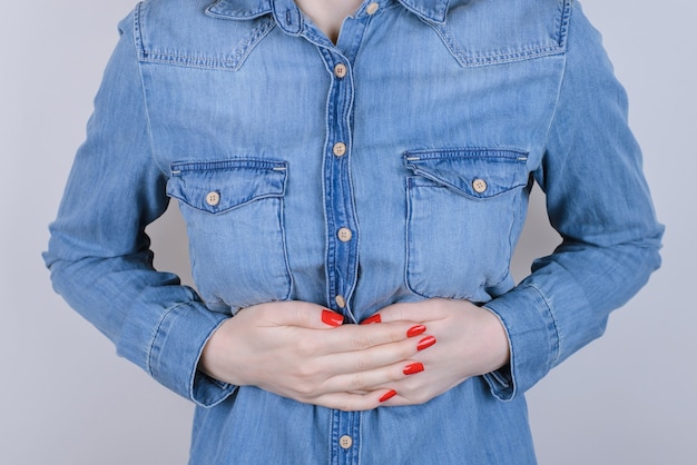 Digestion indigestion people person concept. Cropped close up photo of sad unhappy stressed depressed lady suffering from stomach-ache isolated on gray background