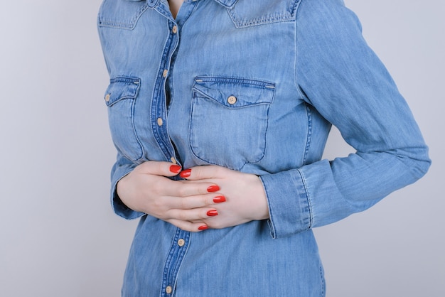 Digestion indigestion people person concept. Cropped close up photo of sad unhappy stressed depressed lady suffering from stomach-ache isolated on gray background