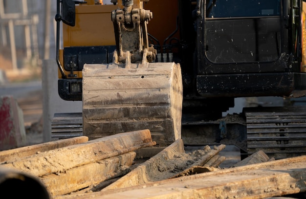 Digger parked at construction site with metal bar Backhoe after work Earth moving machine Excavation vehicle Construction site with excavator Infrastructure development Construction industry