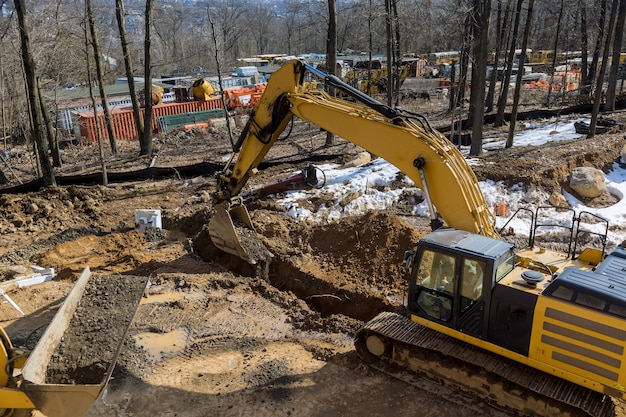 Photo digging trench for drain system with trench under construction road