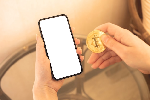 Digitaal geldmodel, betaal met bitcoin-concept, vrouw met de mobiele telefoon en gouden munt