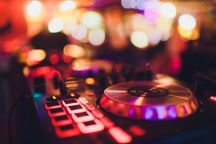 Foto digitaal midi-controllerpaneel met kleurrijk discolicht, geluidsuitrusting voor dj-draaitafelconsole.