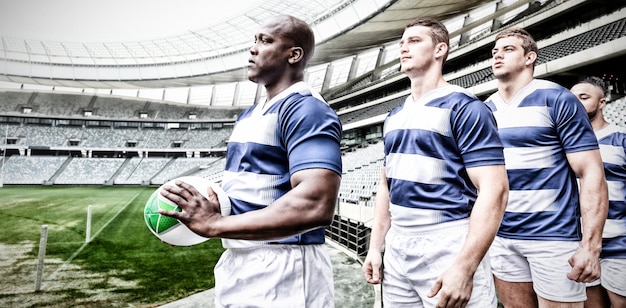 Digitaal samengesteld beeld van een team van rugbyspelers die op een rij staan in het sportstadion