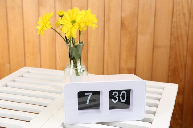 Digital alarm clock on table on wooden background