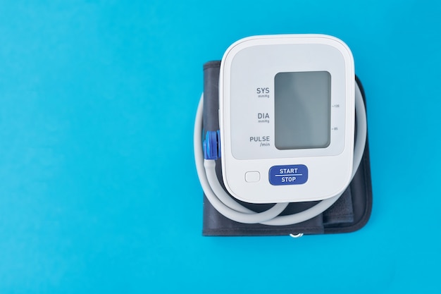 Photo digital blood pressure monitor on blue, closeup. helathcare and medical concept