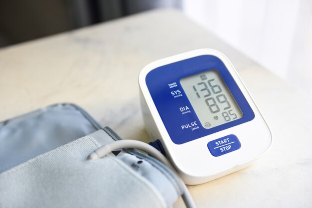 Monitor digitale della pressione sanguigna sulla tavola di legno, tonometro elettronico medico controlla la pressione sanguigna