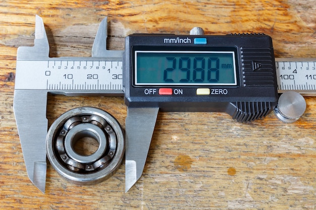 Digital caliper with ball bearing on wooden table