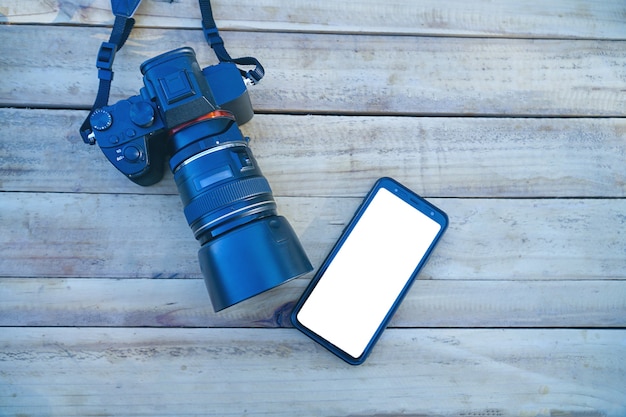 写真 木製の背景技術開発コンセプトのデジタルカメラとスマートフォン。上面図。
