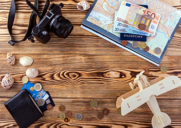 Fotocamera digitale mappa passaporto denaro borsa in legno aereo portafoglio su uno sfondo di legno concetto di viaggio