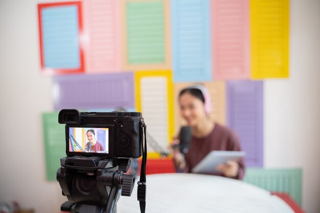 Digital camera screen with tripod recording a girl podcast