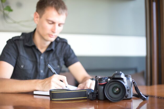 Digital camera on a table on the background of the photographer