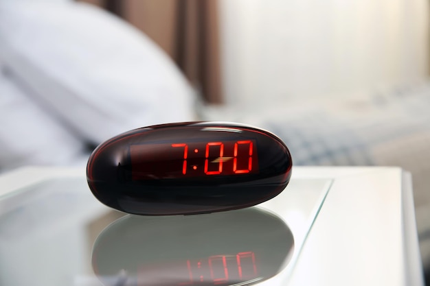 Digital clock on a bedside table in bedroom