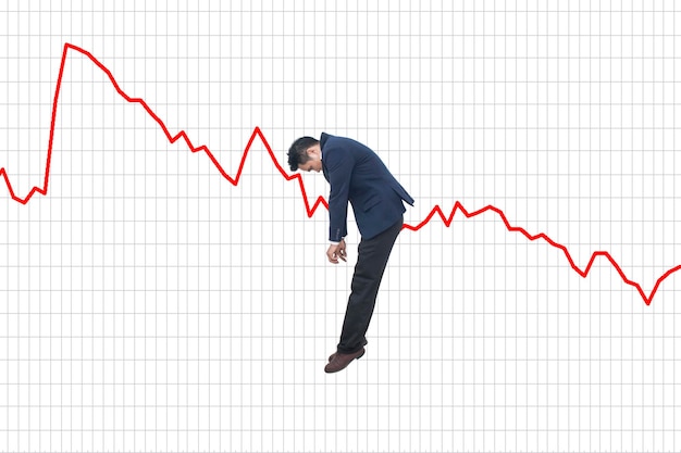 Digital composite image of businessman hanging on line graph