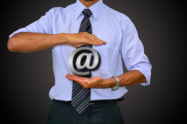 Digital composite image of businessman with at symbol against black background