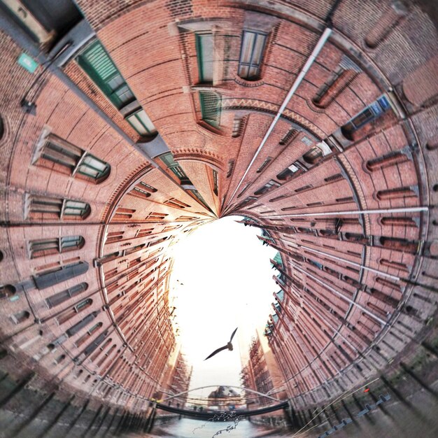 Digital composite image of canal amidst buildings against clear sky