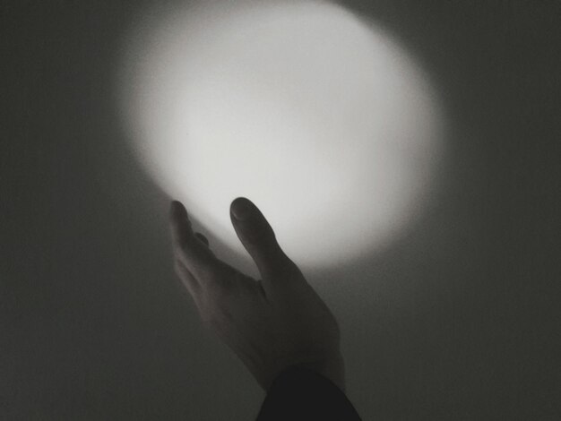 Digital composite image of cropped hand holding light