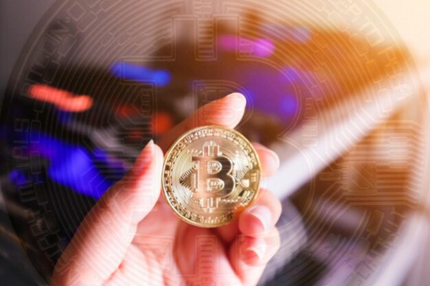 Digital composite image of hand holding bitcoin