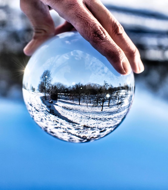Foto immagine composita digitale di una mano che tiene una sfera di cristallo